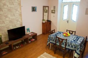 a living room with a table and a television at Guest House Lile in Tbilisi City
