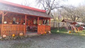 uma pequena casa com um alpendre e um baloiço em Pensiunea agroturistica "Cheile Cibului" em Cib