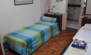 um pequeno quarto com uma cama num quarto em Hotel São Bento em Belo Horizonte