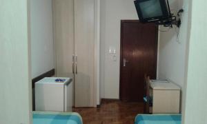 a room with a refrigerator and a television at Hotel São Bento in Belo Horizonte