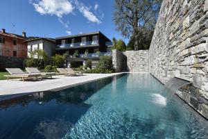 una casa con piscina junto a una pared de piedra en Casa Fantini - Lake Time en Pella