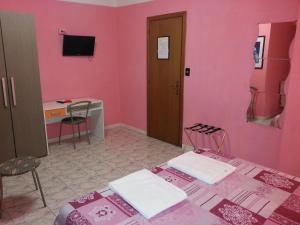 a pink room with two beds and a desk at Roxena house in Rome