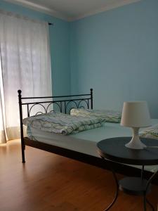 un letto in una camera con tavolo e lampada di Casa dei Cigni a Cannobio