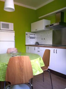 una cucina con tavolo, sedie e parete verde di Casa dei Cigni a Cannobio