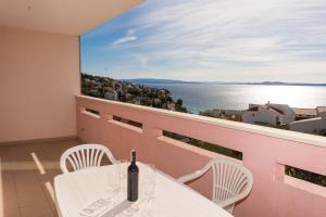 a table with a bottle of wine on a balcony at Apartment Pavic-Nikic in Trogir