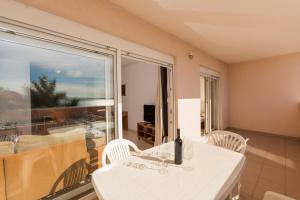 a room with a white table and chairs and a balcony at Apartment Pavic-Nikic in Trogir