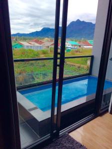 een raam met uitzicht op een buitenzwembad bij Prai Fhan View in Mae Sai