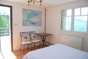 a bedroom with a bed and two chairs and a table at Auberge St P Vegetarien BnB in Saint-Pastous