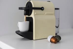 a coffee machine with a cup on a counter at Euryclea Residences in Athens +35 photos