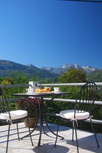 a table and chairs on a balcony with a view at Auberge St P Vegetarien BnB in Saint-Pastous