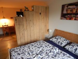 1 dormitorio con 1 cama y pared de madera en B&B Annabelle en Schüttorf