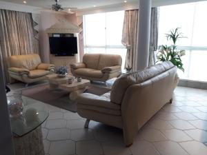 a living room with a couch and chairs and a tv at Boulevard 501 in Margate