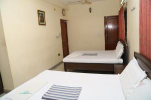 Habitación pequeña con 2 camas y espejo. en Star Residency, en Chennai