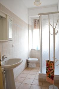 a white bathroom with a sink and a toilet at Silvio in Massa Marittima