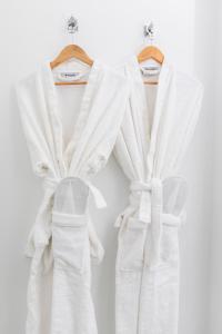 two white robe hanging on a rack at Euryclea Residences in Athens