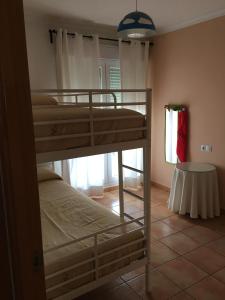 2 Etagenbetten in einem Zimmer mit Fenster in der Unterkunft Apartamento Mirador de Castilnovo in Conil de la Frontera