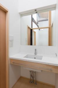 a bathroom with a sink and a mirror at BenTen Residences in Kyoto