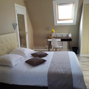 een slaapkamer met een groot bed met 2 kussens erop bij Hôtel Normand Yport Hôtel Ambiance familiale non étoilé in Yport