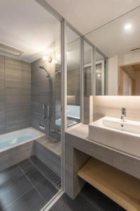 a bathroom with a tub and a sink and a shower at BenTen Residences in Kyoto