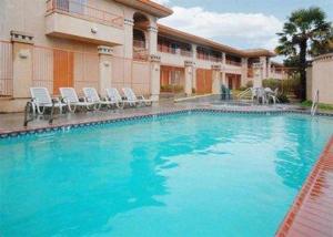 a large pool with blue water in front of a building at Americas Best Value Inn Manteca in Manteca