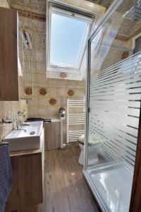 een badkamer met een douche, een wastafel en een raam bij Ferienwohnungen Saarn in Mülheim an der Ruhr