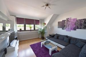 een woonkamer met een blauwe bank en een paars tapijt bij Ferienwohnungen Saarn in Mülheim an der Ruhr