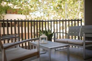 eine Terrasse mit 2 Stühlen und einem Tisch mit einer Laterne in der Unterkunft Casa Manu in Misano Adriatico