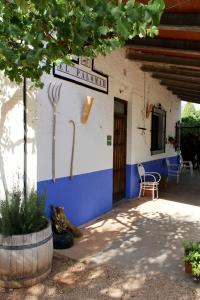 a blue and white building with a table and a chair at Casas Rurales el Palomar in Ossa de Montiel
