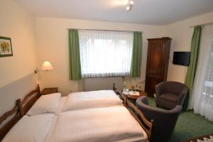 um quarto com 2 camas, uma mesa e uma cadeira em Hotel Central em Bad Sooden-Allendorf