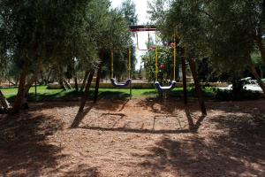 un columpio en un parque con árboles en Casas Rurales el Palomar en Ossa de Montiel