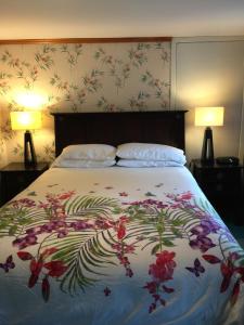 a bedroom with a bed with a floral bedspread at Dreamweavers Cottages and Home Place Vacation Home in Rustico