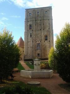 un gran edificio de piedra con una fuente frente a él en Les Calaubys en Huriel