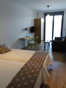 コカにあるApartamentos La Rocandaのベッドルーム1室(ベッド1台付)、リビングルーム(テーブル付)