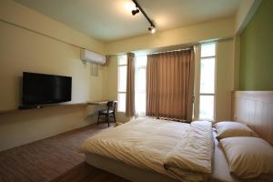 um quarto de hotel com uma cama e uma televisão em Coffee Tree em Lukang