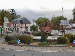 a statue of a hand on the side of a street at Les Calaubys in Huriel