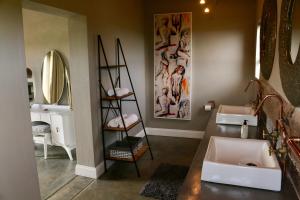 a bathroom with two sinks and a shelf with mirrors at Libertas Guest Farm in Hoekwil +207 photos