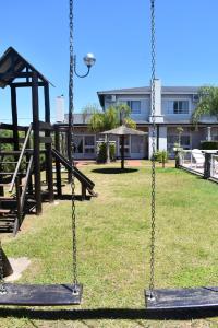 a swing in a park with a building in the background at Amancay del Urugua-i in Colón