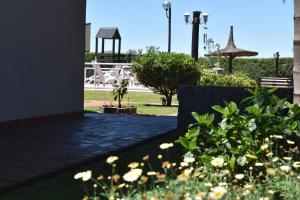 un giardino con gazebo e alcuni fiori di Amancay del Urugua-i a Colón