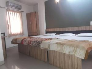 two twin beds in a bedroom with a window at Hotel Pariwar in Aurangabad