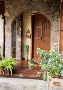 an entrance to a house with a wooden door at Pousada Recanto da Serra in São Pedro da Serra