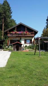 uma casa com uma varanda com flores em Ferienhaus Edelweiss em Sankt Kanzian