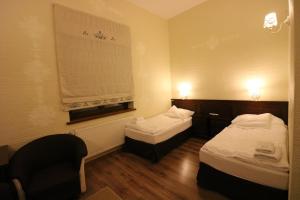una habitación de hotel con 2 camas y una silla en Hotel Marzanna, en Niedrzwica Kościelna