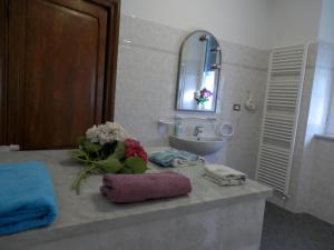 a bathroom with a sink and a counter with flowers on it at Au Cavettu B&B in Varazze