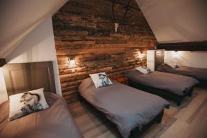 オトゥランにあるLa Grange Aux Feesのレンガの壁の客室内のベッド2台