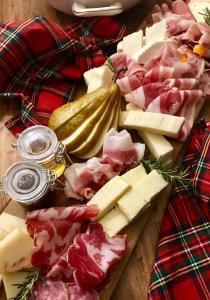 a cutting board with cheese and meats and pickles at Agriturismo Nonna Du in Gavi