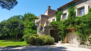 uma antiga casa de pedra com uma escada que o leva até ela em Le Jas des Parpaillous em LʼIsle-sur-la-Sorgue