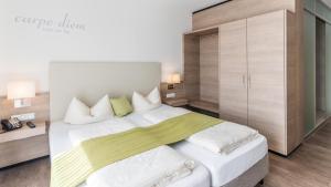 1 dormitorio con 1 cama blanca grande y armario en Parkhotel Pfarrkirchen, en Pfarrkirchen