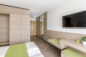 a room with a flat screen tv on a wall at Parkhotel Pfarrkirchen in Pfarrkirchen