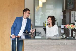 a man and a woman standing at a bar at Parkhotel Pfarrkirchen in Pfarrkirchen