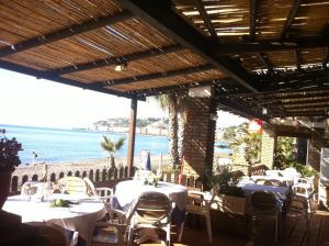 アルムニェーカルにあるCasa Marianaのテーブルと椅子が備わり、海の景色を望むレストラン